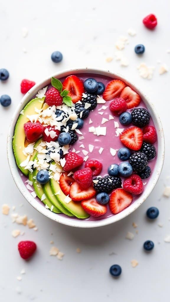 A bowl of Avocado Berry Bliss Smoothie topped with berries, avocado slices, and coconut flakes.